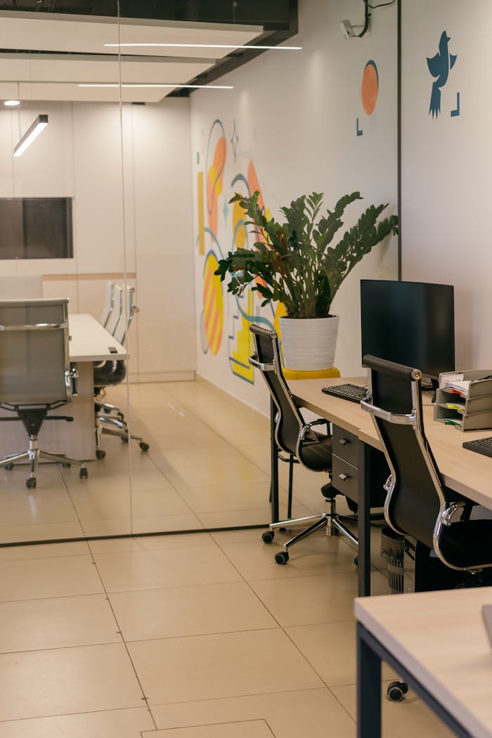 services-03 Spacious and contemporary office interior with glass partitions, stylish furniture, and vibrant wall art.